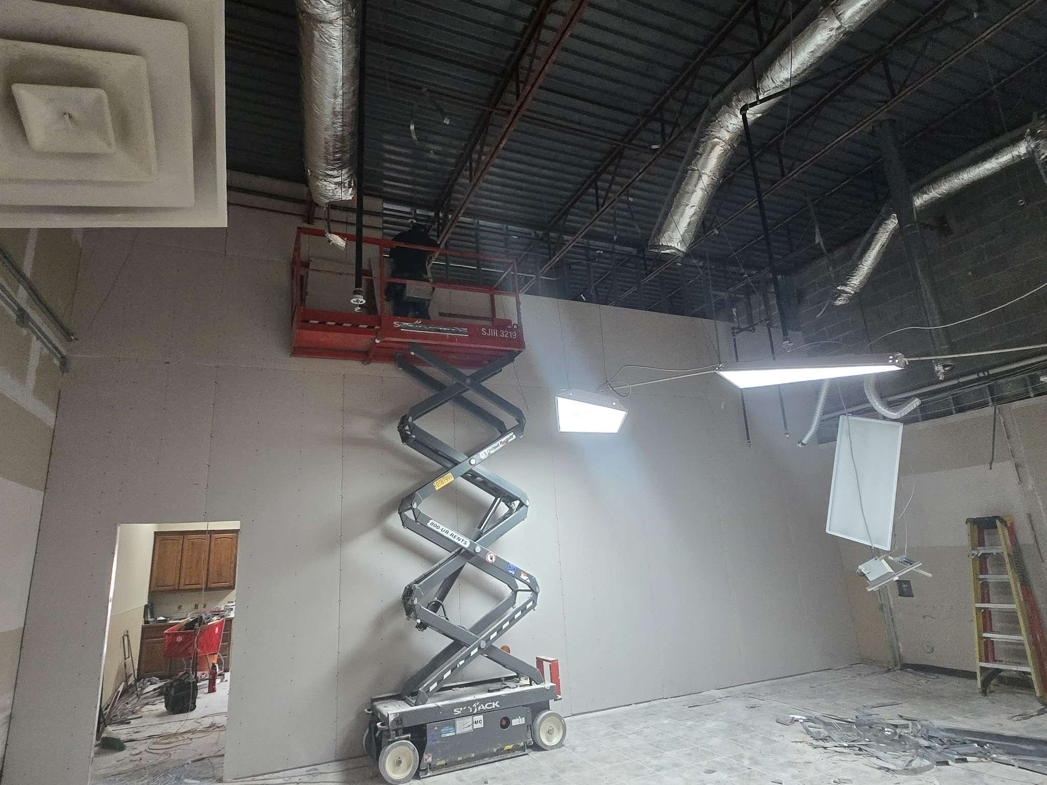 Scissor lift providing overhead access inside an Austin commercial interior